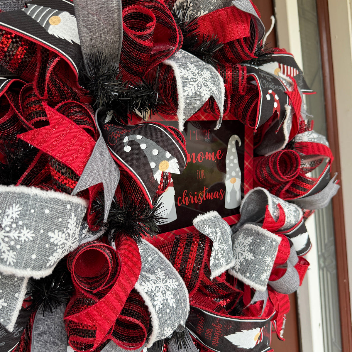 Handmade Christmas gnome deco mesh wreath with red, black, and gray snowflake ribbons and I'll Be Gnome for Christmas sign.