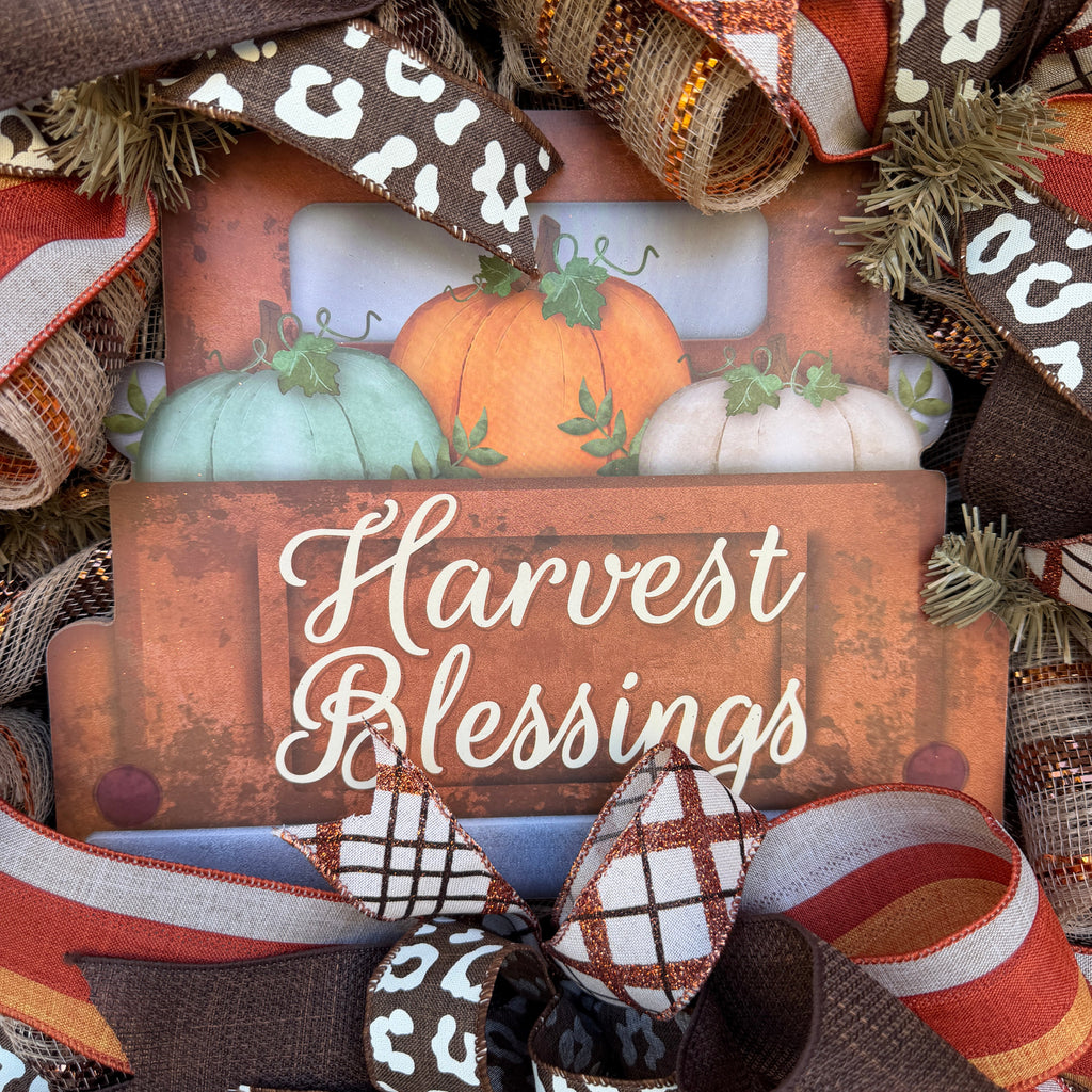 Harvest Blessings wreath. Rich pumpkin orange, deep brown, cream, and soft green come together in a full, layered design that feels cozy, cheerful, and perfect for the season.