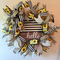 Handmade sunflower farmhouse wreath featuring black and white striped ribbons, sunflower accents, burlap details, and a rustic hello sign for front door decor.