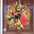 Handmade strawberry summer wreath featuring red gingham ribbons, strawberry print accents, greenery, and a large strawberry centerpiece hanging on a front door.