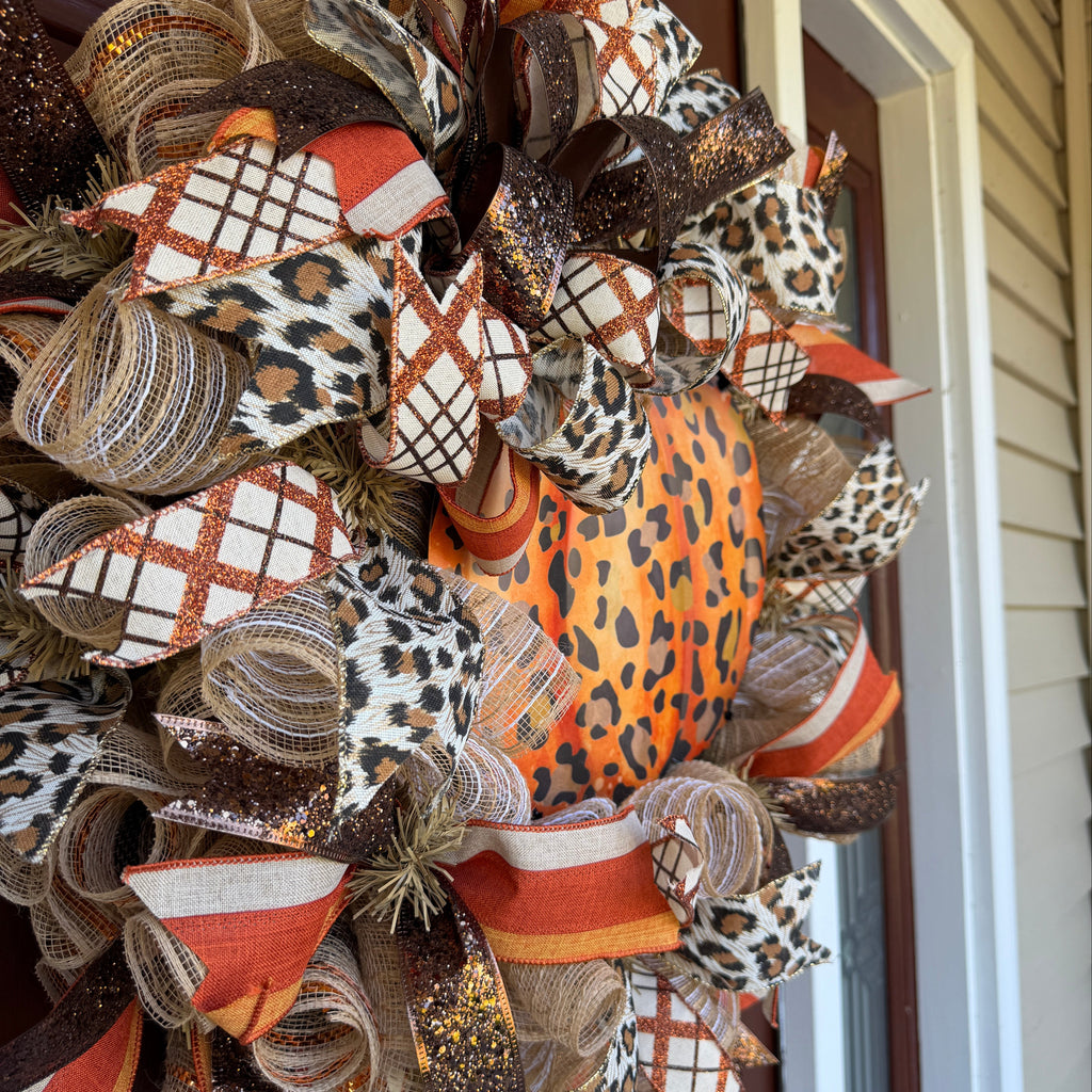 Make your front door feel bold, warm, and a little unexpected this fall with this playful leopard pumpkin wreath. Rich autumn orange, warm brown, cream, and black come together with animal-print accents for a look that feels festive without being ordinary.