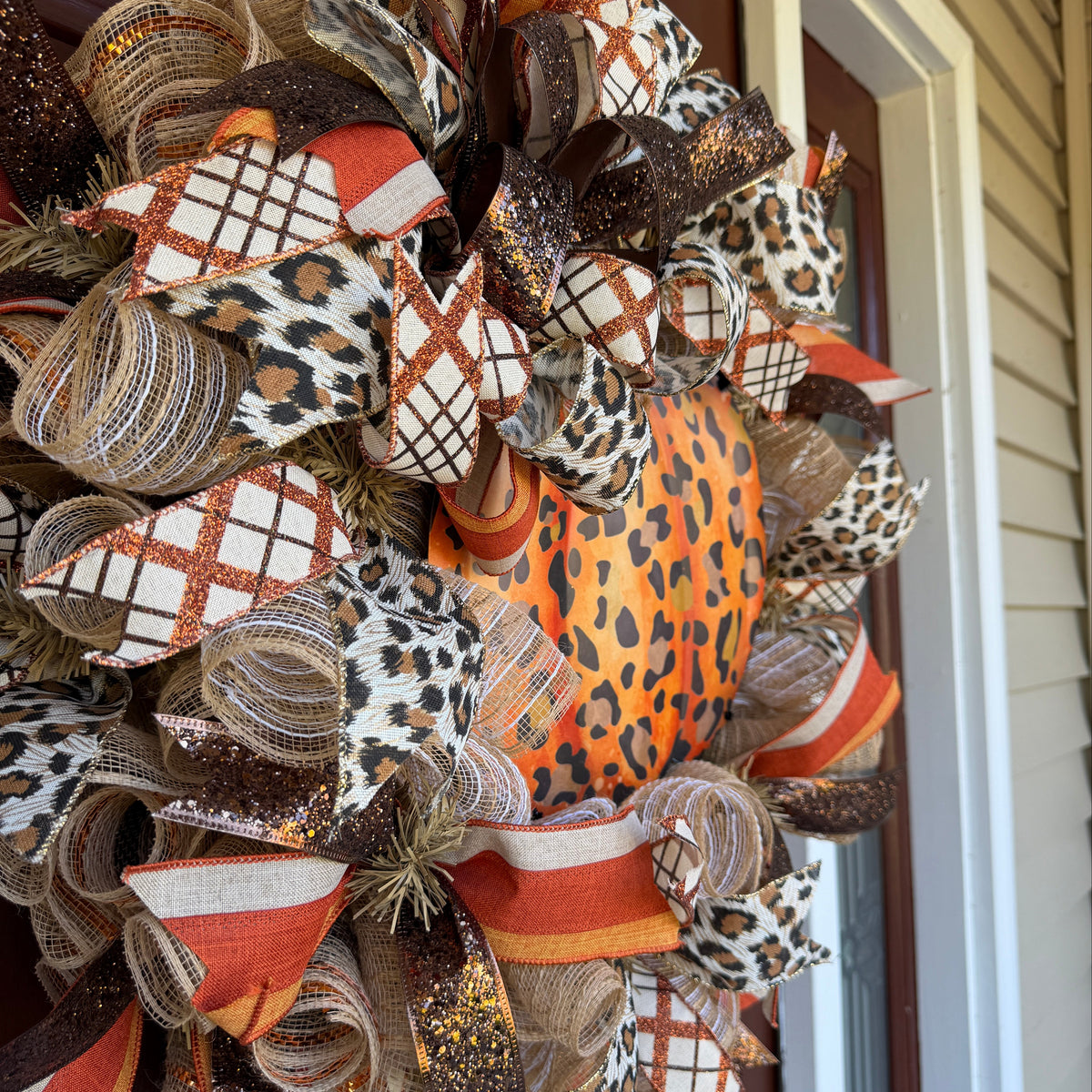 Make your front door feel bold, warm, and a little unexpected this fall with this playful leopard pumpkin wreath. Rich autumn orange, warm brown, cream, and black come together with animal-print accents for a look that feels festive without being ordinary.