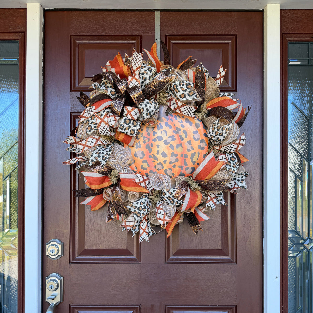 leopard pumpkin wreath. Rich autumn orange, warm brown, cream, and black come together with animal-print accents for a look that feels festive without being ordinary.