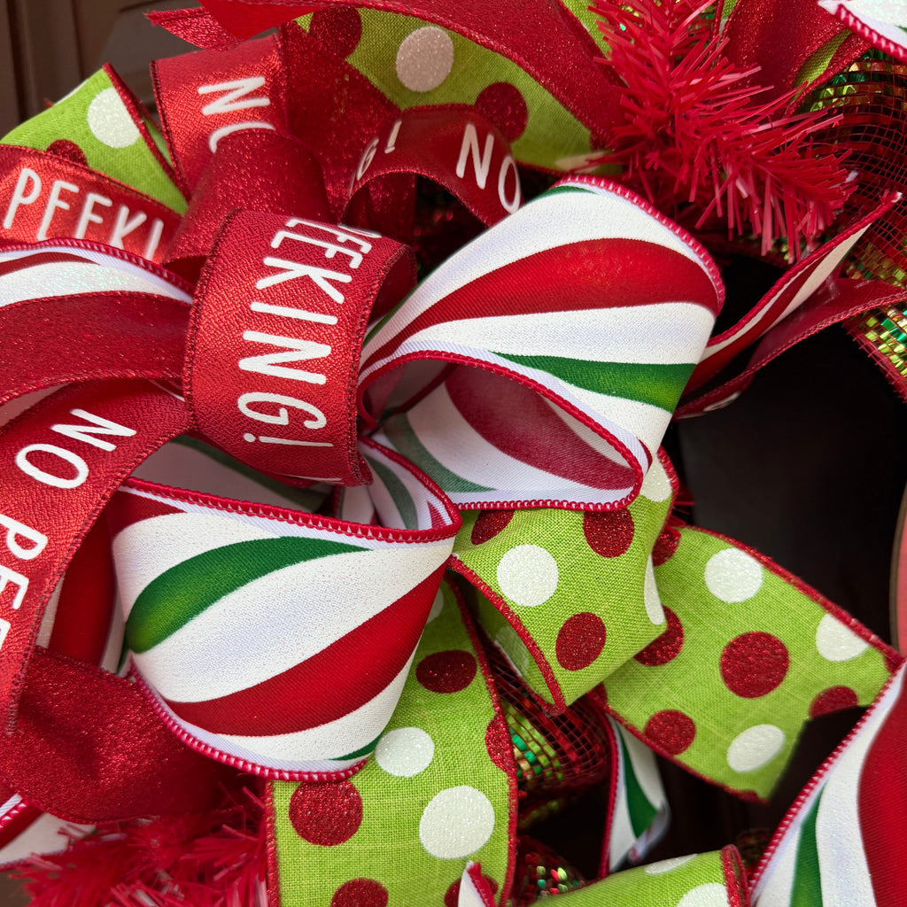 Handmade red and lime green Christmas deco mesh wreath with striped ribbons, No Peeking accents, and Merry Christmas sign.