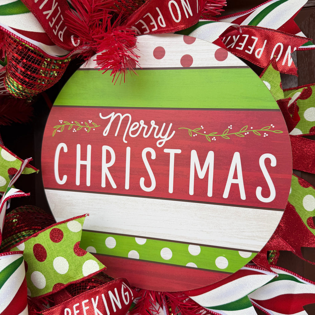 Handmade red and lime green Christmas deco mesh wreath with striped ribbons, No Peeking accents, and Merry Christmas sign.
