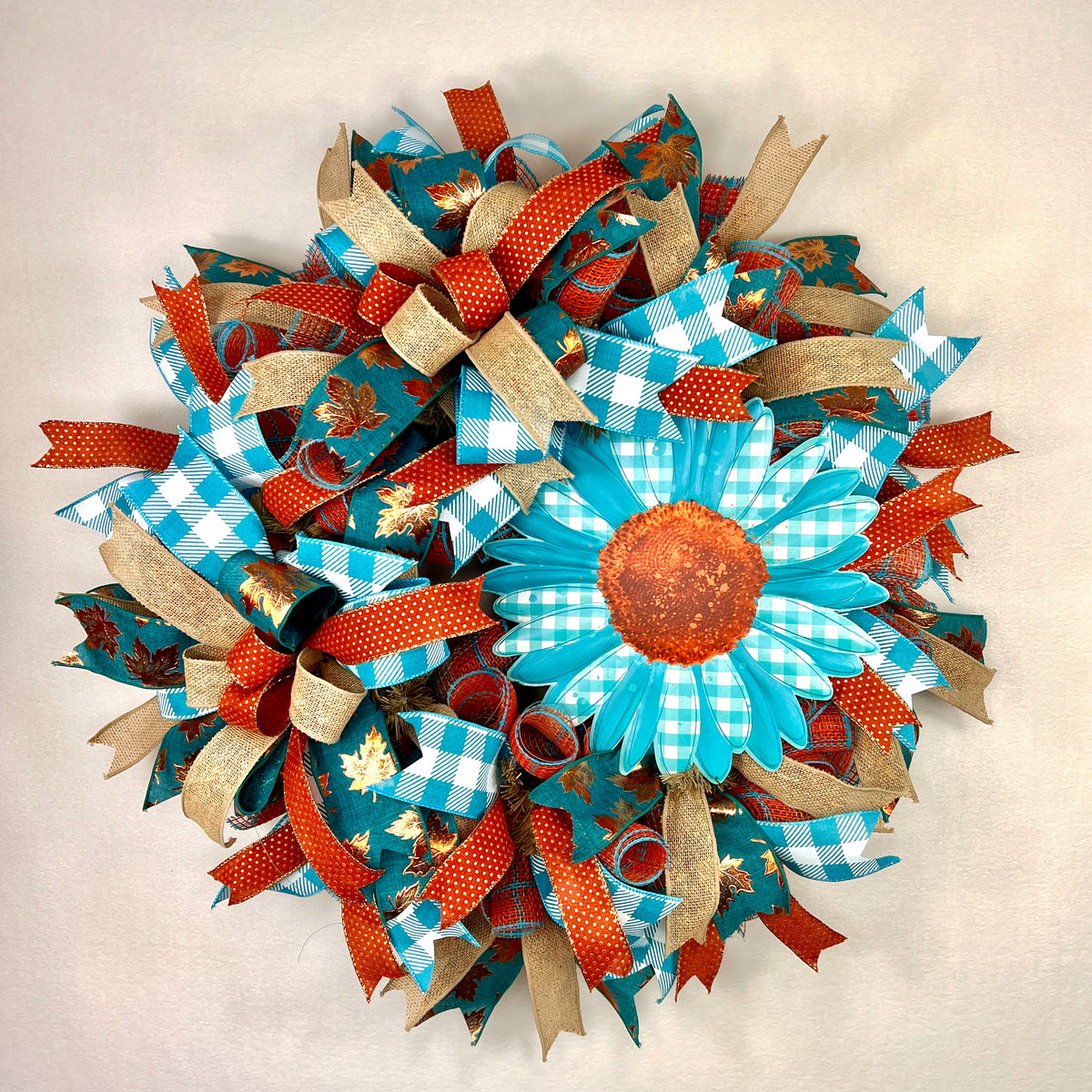 Teal sunflower fall wreath with orange, cream, and plaid ribbons.