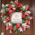 Handmade red and green Christmas deco mesh wreath with glittery ribbons, holly accents, and Meet Me Under the Mistletoe sign