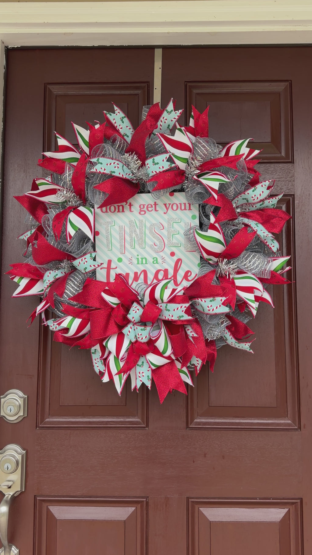 Handmade Christmas deco mesh wreath with silver mesh, red glitter ribbons, candy cane accents, and Don't Get Your Tinsel in a Tangle sign.