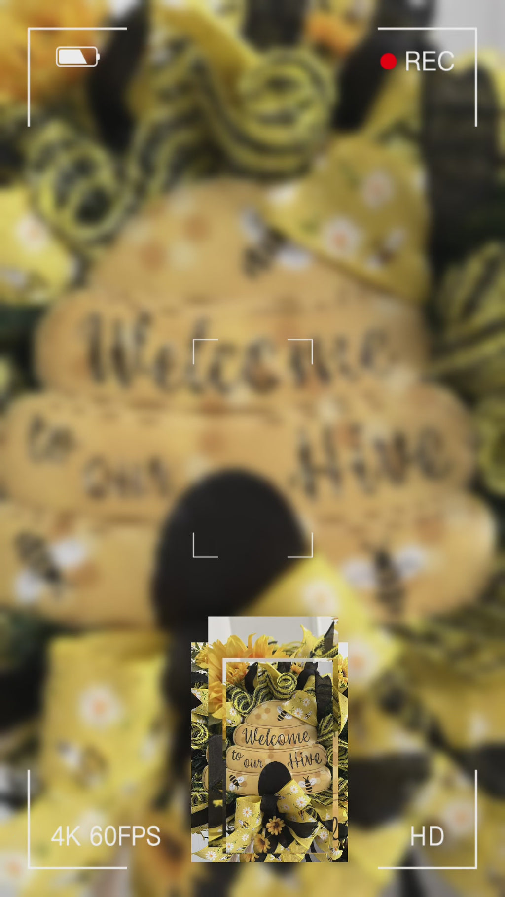 Handmade bee and sunflower wreath featuring a Welcome to Our Hive sign, yellow and black ribbons, daisy accents, and bright sunflowers for summer front door decor.