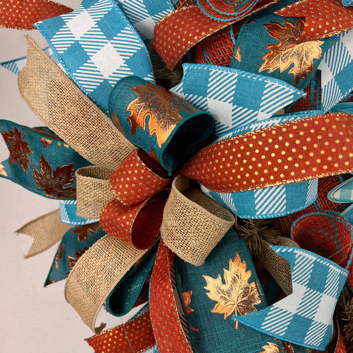 Teal sunflower fall wreath with orange, cream, and plaid ribbons.