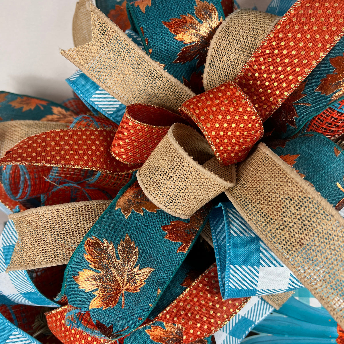 Teal sunflower fall wreath with orange, cream, and plaid ribbons.